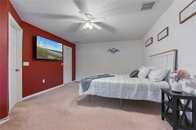 bedroom featuring light carpet, a textured ceiling, and ceiling fan