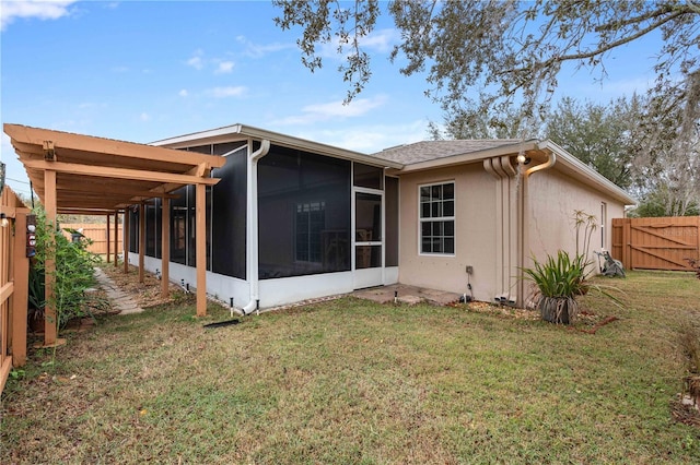 back of property featuring a sunroom and a lawn