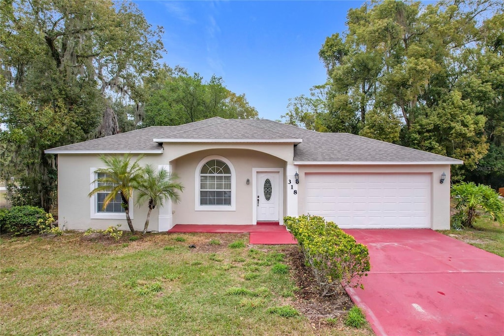 single story home with a garage and a front yard