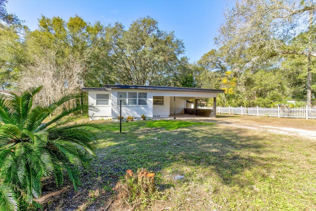 ranch-style home with a carport and a front lawn