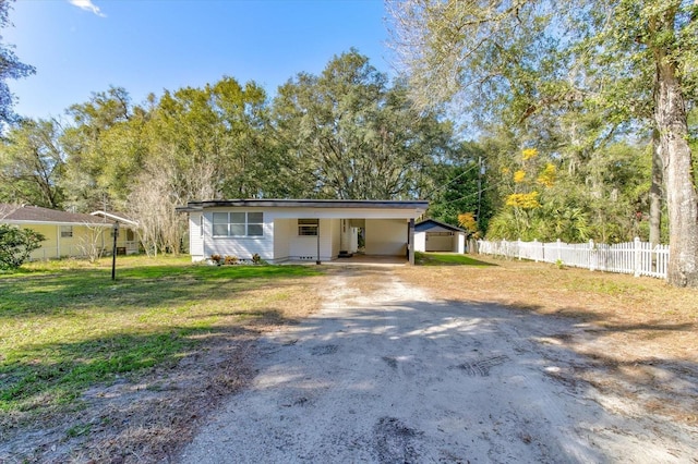 ranch-style house featuring a carport, a garage, and a front yard