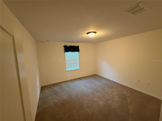 carpeted spare room featuring a textured ceiling