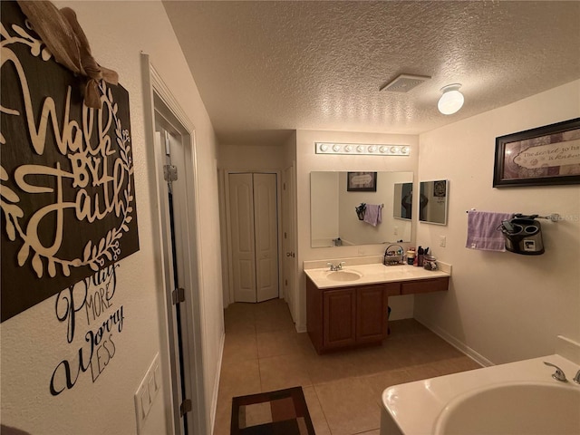 bathroom with vanity, tile patterned floors, and a textured ceiling