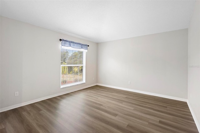 empty room with dark hardwood / wood-style flooring