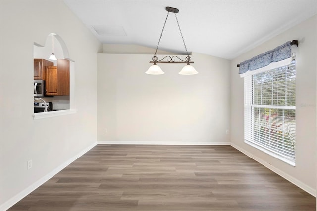 unfurnished dining area featuring hardwood / wood-style flooring and vaulted ceiling