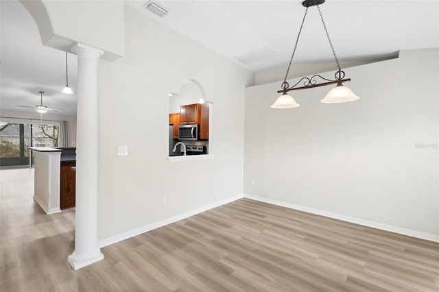 interior space with light hardwood / wood-style flooring, ceiling fan, and ornate columns