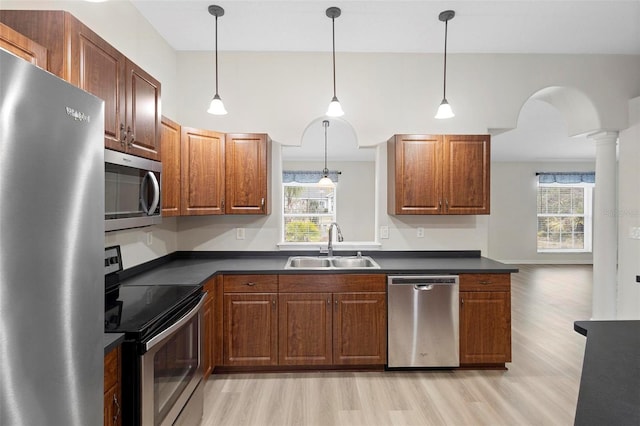 kitchen with pendant lighting, sink, stainless steel appliances, plenty of natural light, and light wood-type flooring