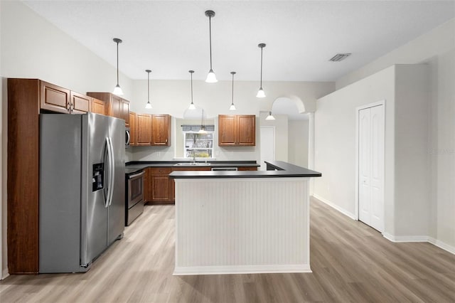 kitchen featuring decorative light fixtures, sink, a center island, light hardwood / wood-style floors, and stainless steel appliances