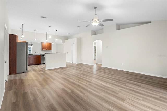 unfurnished living room with ceiling fan, high vaulted ceiling, and light hardwood / wood-style flooring