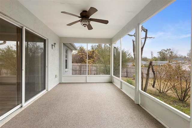 unfurnished sunroom with ceiling fan