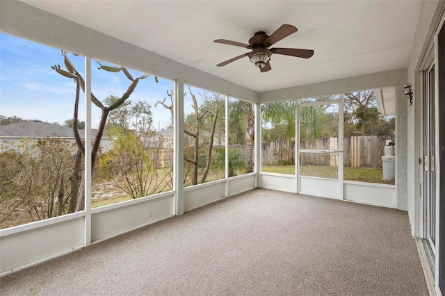 unfurnished sunroom featuring ceiling fan