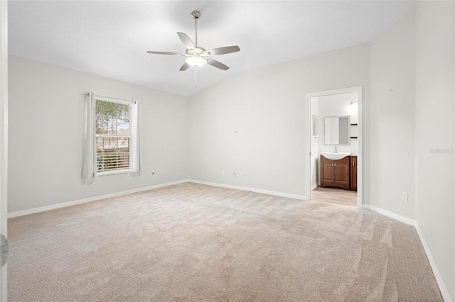 empty room with lofted ceiling, sink, light colored carpet, and ceiling fan