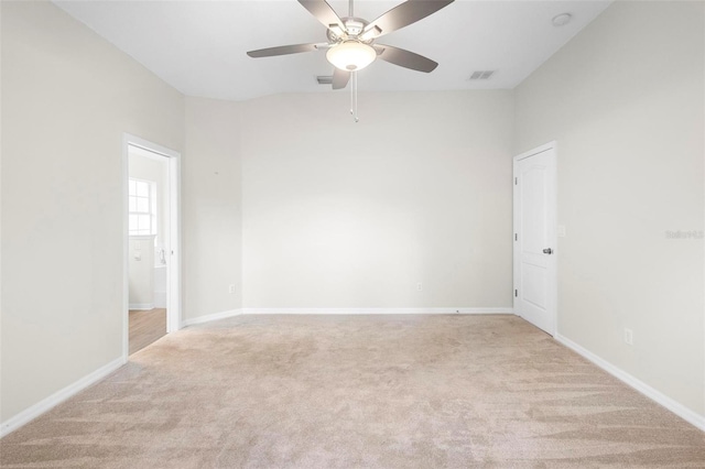 carpeted spare room featuring ceiling fan