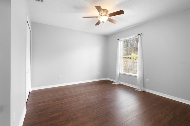 empty room featuring dark wood-type flooring, ceiling fan, and a textured ceiling