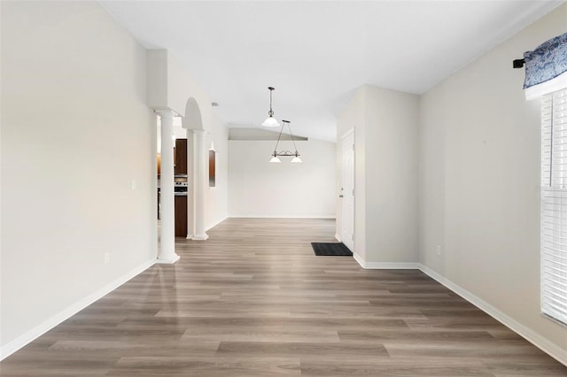 hall with ornate columns, vaulted ceiling, and hardwood / wood-style floors