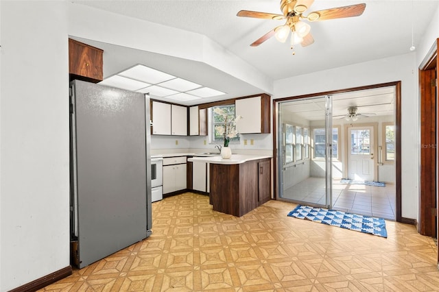 kitchen featuring sink, stainless steel refrigerator, dishwashing machine, electric stove, and ceiling fan