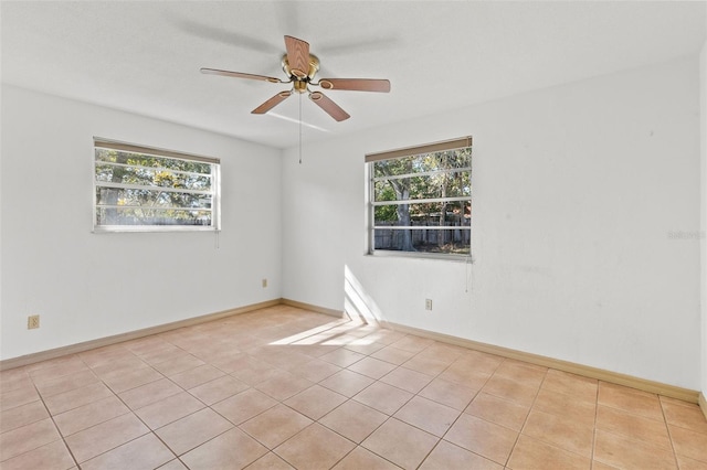 tiled spare room with ceiling fan and a healthy amount of sunlight