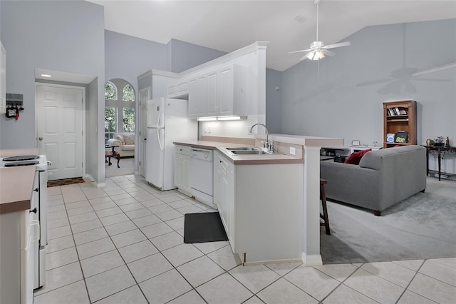 kitchen with sink, white appliances, a kitchen breakfast bar, and white cabinets