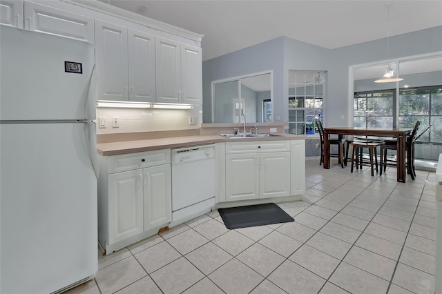 kitchen with sink, light tile patterned floors, pendant lighting, white appliances, and white cabinets