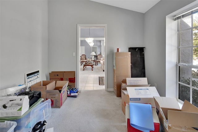 office area with vaulted ceiling, light colored carpet, and an inviting chandelier