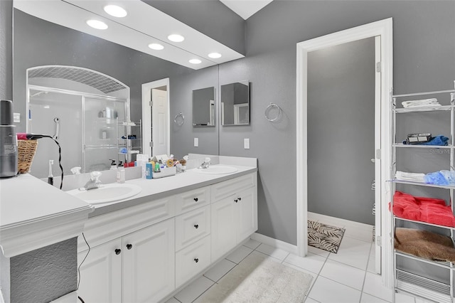 bathroom featuring tile patterned floors, a shower with door, and vanity