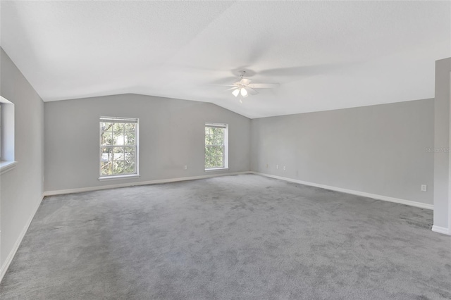 carpeted spare room with vaulted ceiling and ceiling fan