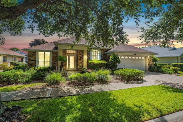 view of front of home with a garage and a yard