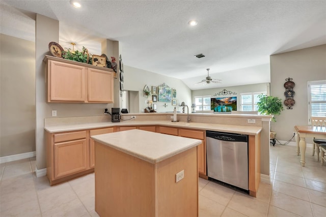 kitchen with stainless steel dishwasher, a center island, kitchen peninsula, and light brown cabinets