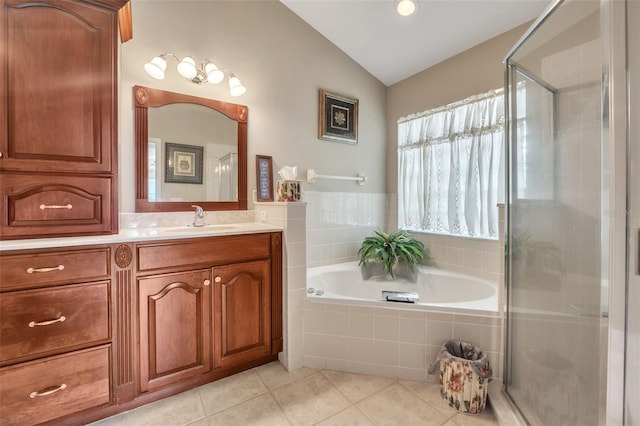 bathroom with tile patterned floors, vanity, shower with separate bathtub, and vaulted ceiling