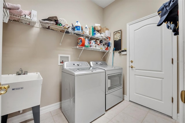 laundry room featuring sink, washer and dryer, and light tile patterned flooring