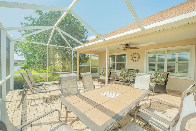 sunroom / solarium with a water view and ceiling fan