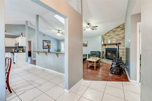 interior space with light tile patterned floors and vaulted ceiling