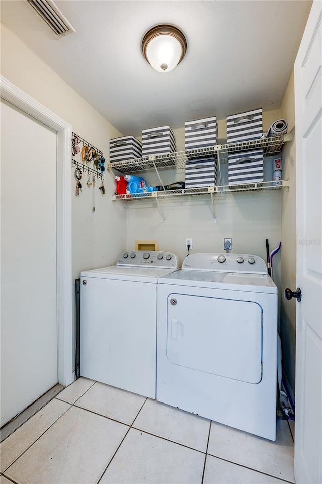 laundry area featuring light tile patterned floors and washer and clothes dryer