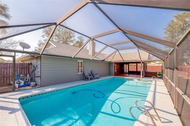 view of pool with an outdoor hot tub, a patio area, and glass enclosure