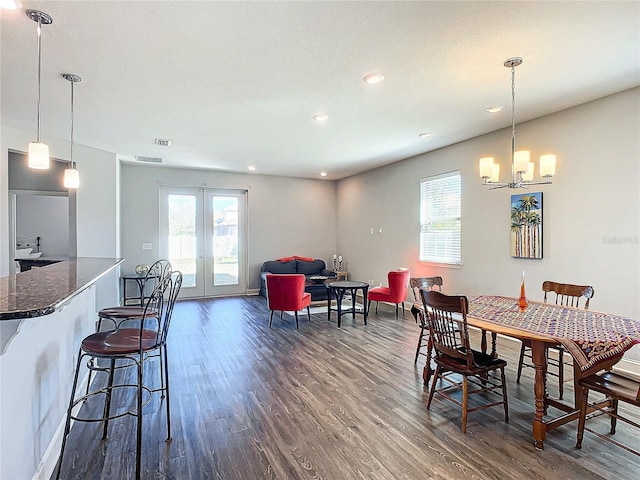 dining area featuring french doors, dark hardwood / wood-style floors, and a notable chandelier