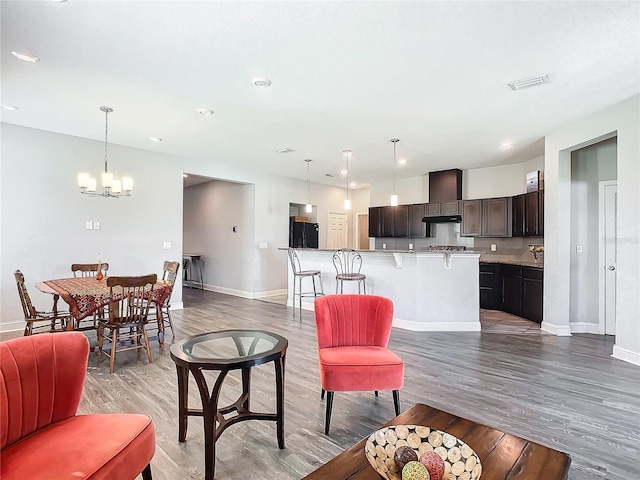 living room with hardwood / wood-style flooring and an inviting chandelier