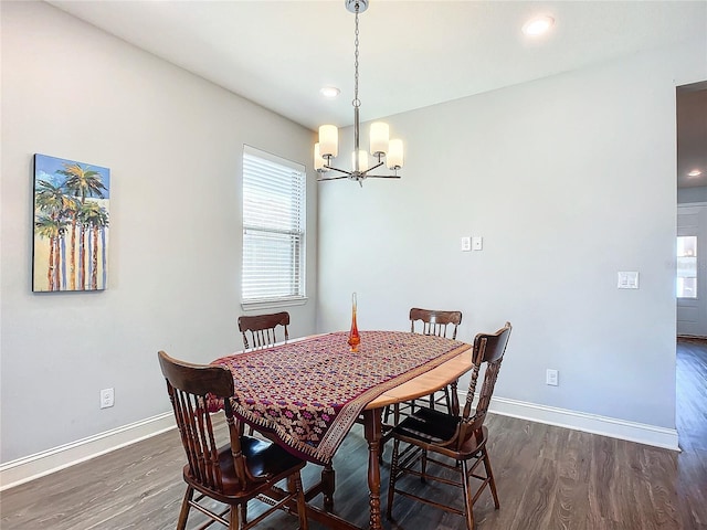 dining space featuring dark wood-type flooring and a notable chandelier