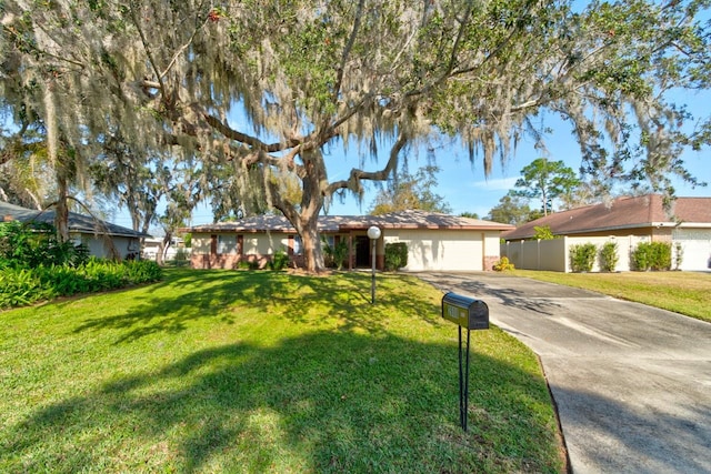 ranch-style home featuring a garage and a front lawn