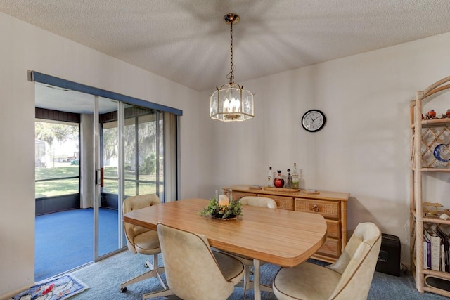 dining space featuring a notable chandelier, carpet floors, and a textured ceiling