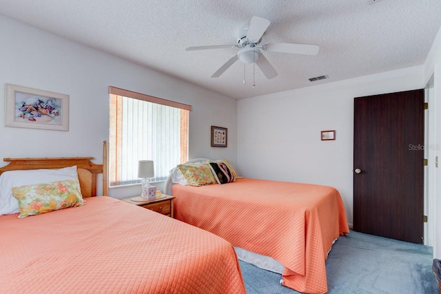 carpeted bedroom with a textured ceiling and ceiling fan