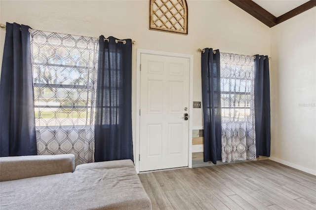 entryway featuring vaulted ceiling with beams and light hardwood / wood-style flooring