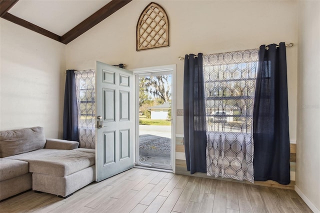 doorway to outside featuring high vaulted ceiling and beamed ceiling