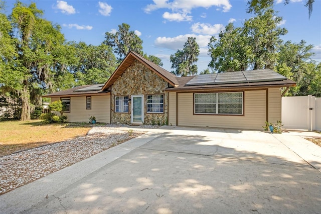 1240 W Voorhis Ave, Deland, FL 32720 - ranch-style home featuring fence, roof mounted solar panels, and concrete driveway