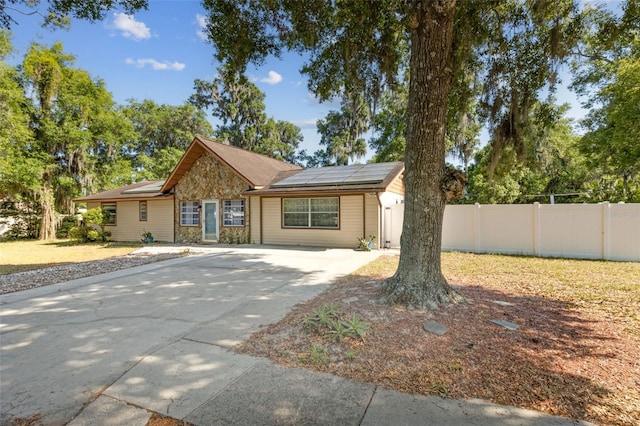 1240 W Voorhis Ave, Deland, FL 32720 - ranch-style house featuring fence, solar panels, and driveway