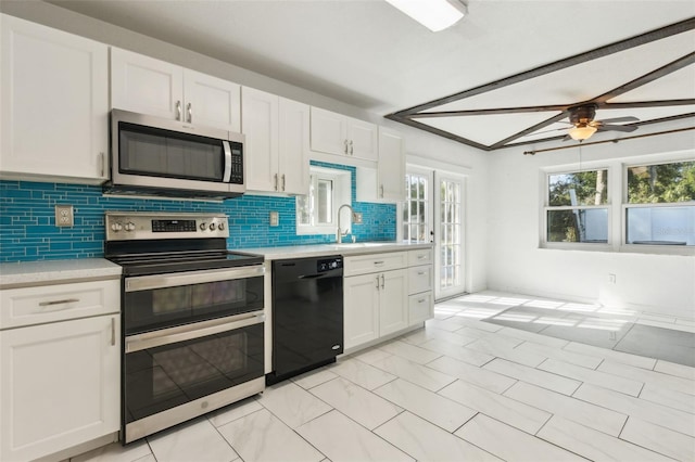 1240 W Voorhis Ave, Deland, FL 32720 - kitchen featuring a sink, stainless steel appliances, backsplash, light countertops, and white cabinets