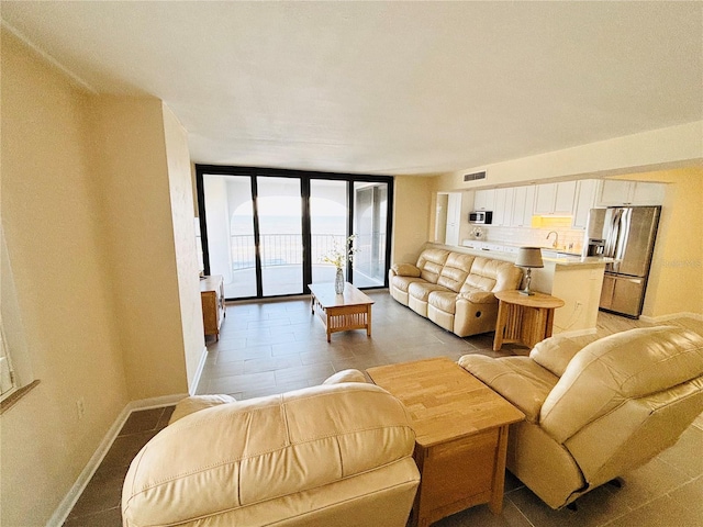 living room with sink and a wall of windows