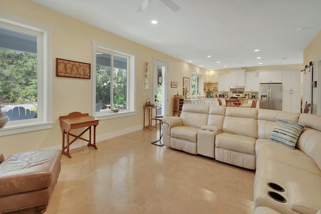 living room featuring a barn door and ceiling fan