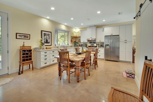 dining space with sink and a barn door