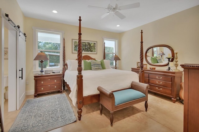 bedroom featuring multiple windows, a barn door, and ceiling fan