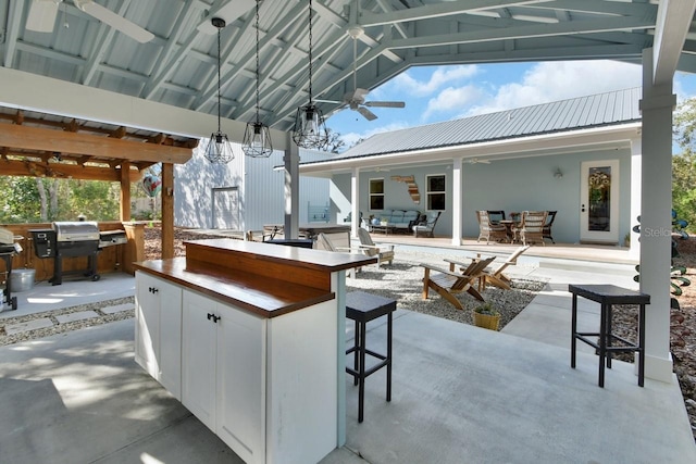 view of patio / terrace featuring an outdoor bar, ceiling fan, a gazebo, area for grilling, and an outdoor hangout area